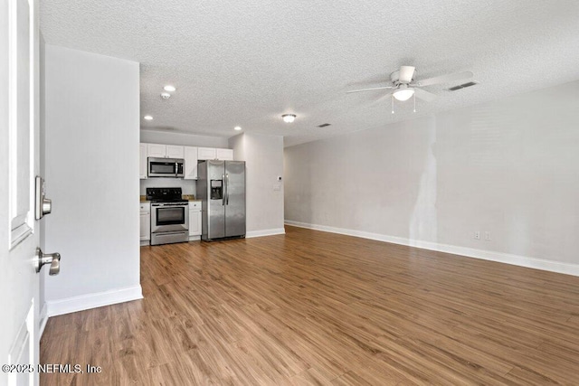 unfurnished living room with a textured ceiling, light wood-type flooring, and ceiling fan