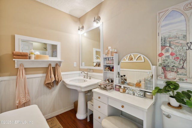 bathroom featuring a textured ceiling, hardwood / wood-style flooring, and toilet