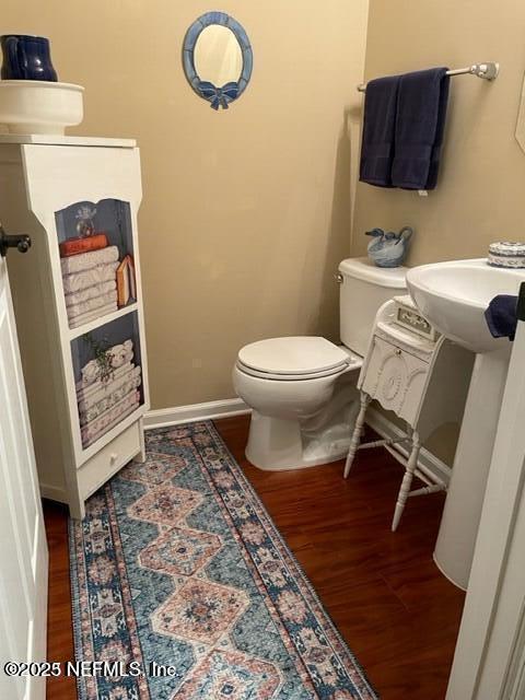 bathroom with wood-type flooring and toilet