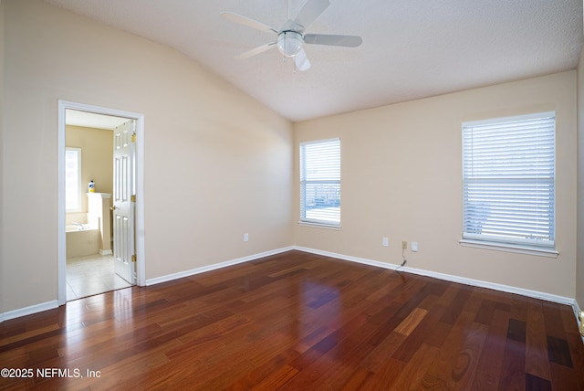 unfurnished room with vaulted ceiling, wood finished floors, a ceiling fan, and baseboards