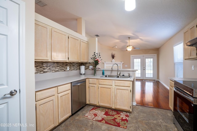 kitchen featuring light brown cabinets, a peninsula, a sink, appliances with stainless steel finishes, and french doors