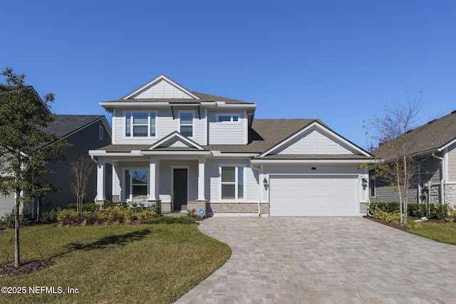 craftsman-style home with covered porch, a garage, and a front lawn