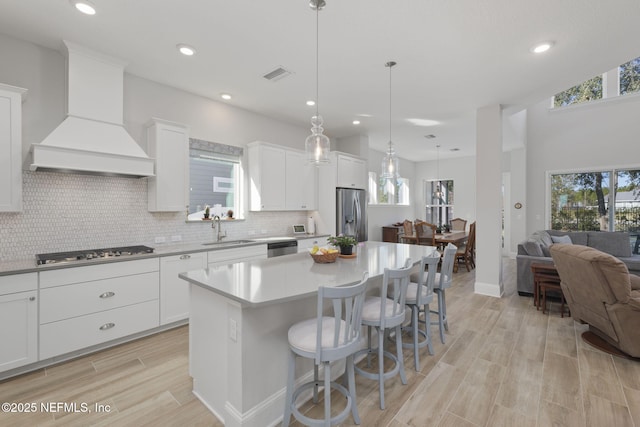 kitchen featuring white cabinets, appliances with stainless steel finishes, sink, and custom exhaust hood