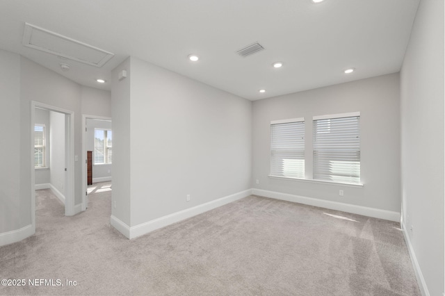 spare room with recessed lighting, visible vents, light carpet, and baseboards