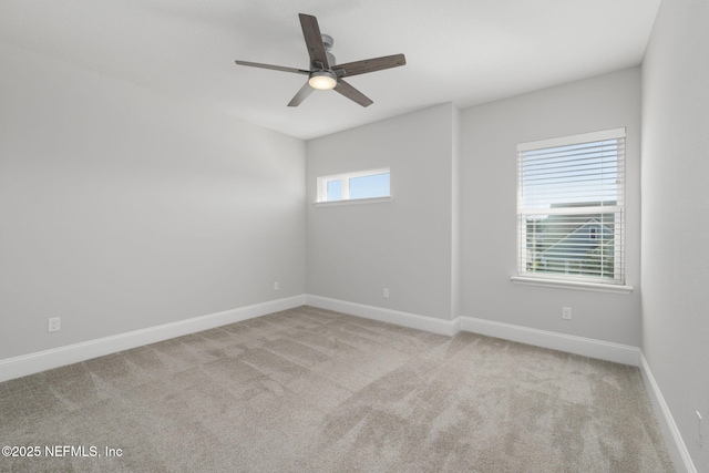 empty room featuring ceiling fan, plenty of natural light, and light colored carpet