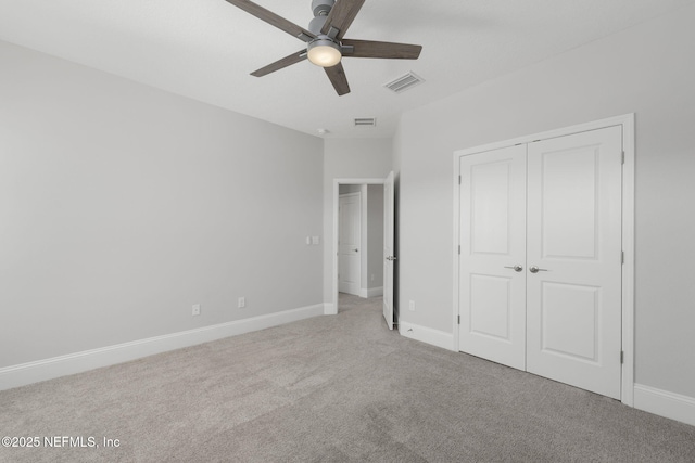 unfurnished bedroom featuring ceiling fan, light colored carpet, and a closet