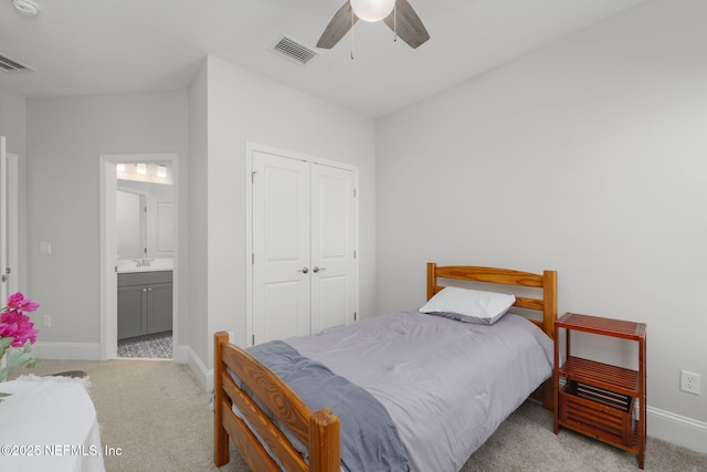 carpeted bedroom with ensuite bath, ceiling fan, and a closet