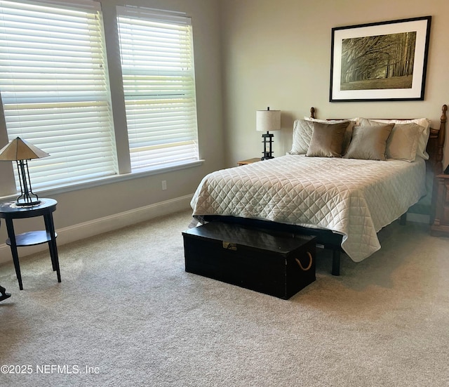 carpeted bedroom featuring multiple windows and baseboards