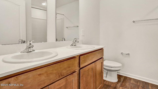 bathroom featuring vanity, wood-type flooring, and toilet