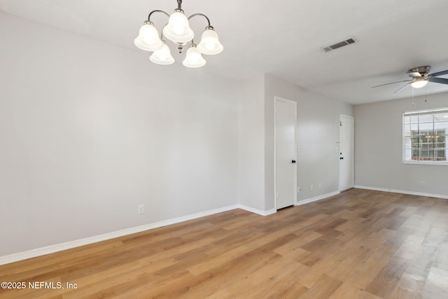 empty room featuring hardwood / wood-style floors and ceiling fan with notable chandelier