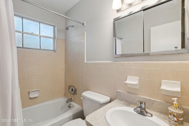 full bathroom featuring toilet, sink, shower / bathtub combination with curtain, and tile walls