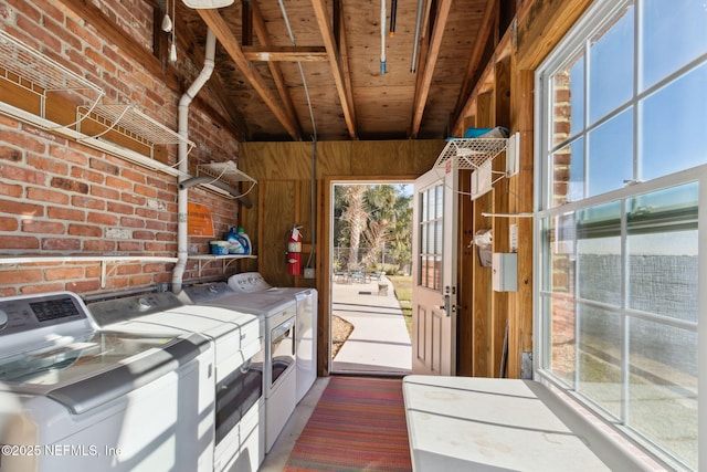 interior space with separate washer and dryer, a wealth of natural light, and wood walls