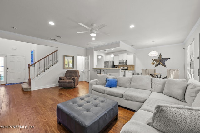 living room featuring wood-type flooring, ceiling fan, and ornamental molding