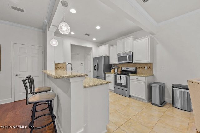 kitchen with kitchen peninsula, white cabinetry, pendant lighting, and stainless steel appliances