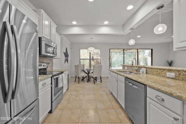 kitchen with white cabinets, appliances with stainless steel finishes, pendant lighting, and sink