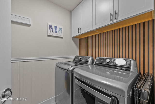 laundry room with washing machine and clothes dryer and cabinets