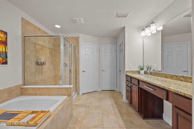 bathroom featuring shower with separate bathtub, vanity, a textured ceiling, and tile patterned floors