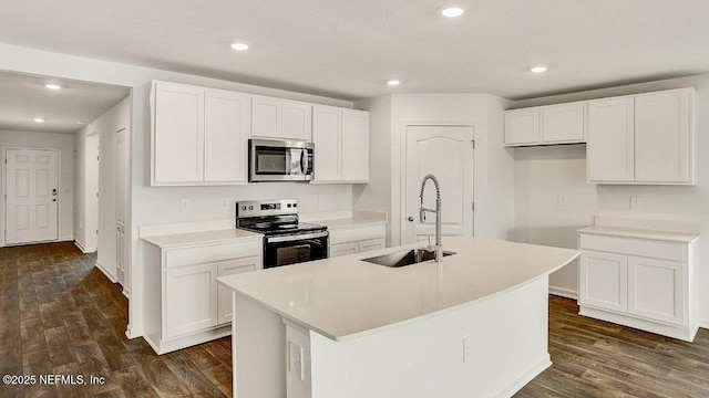 kitchen featuring sink, an island with sink, dark hardwood / wood-style flooring, white cabinetry, and stainless steel appliances