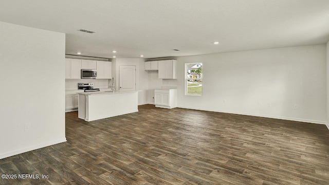 kitchen featuring appliances with stainless steel finishes, sink, a center island with sink, white cabinets, and dark hardwood / wood-style floors