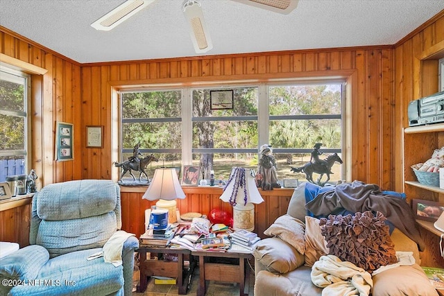 living room featuring ceiling fan and a textured ceiling