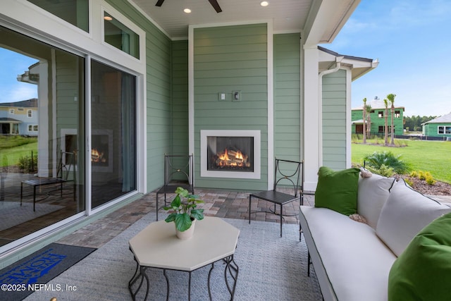 view of patio featuring an outdoor living space with a fireplace and ceiling fan