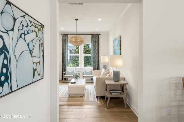 sitting room featuring ornamental molding and hardwood / wood-style flooring