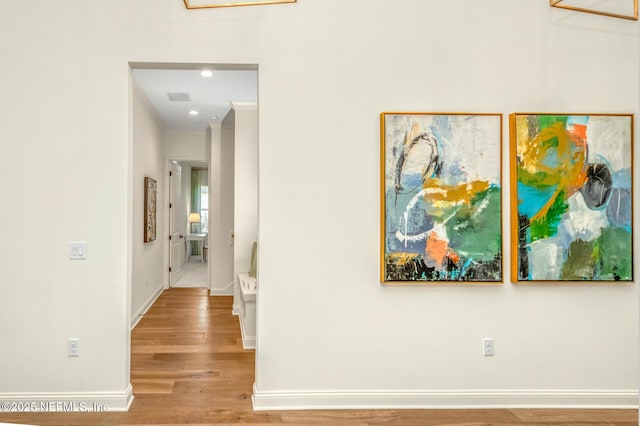 hallway featuring light hardwood / wood-style floors and crown molding