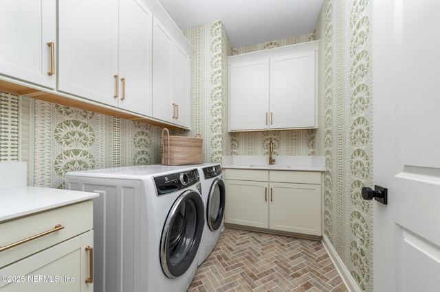 laundry area with washer and clothes dryer, cabinets, and sink