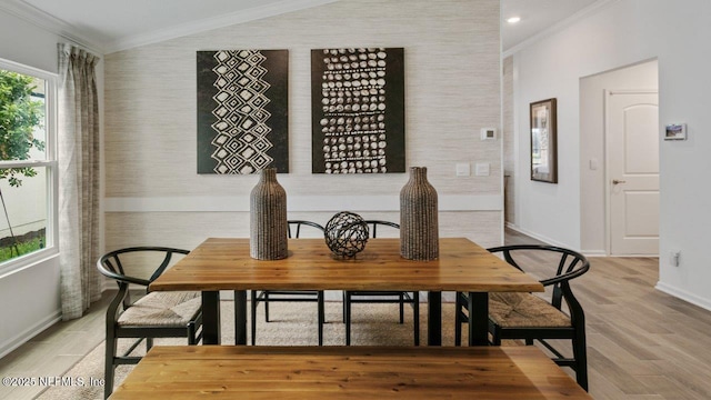 dining space with light wood-type flooring and ornamental molding