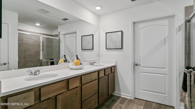 bathroom featuring vanity and an enclosed shower