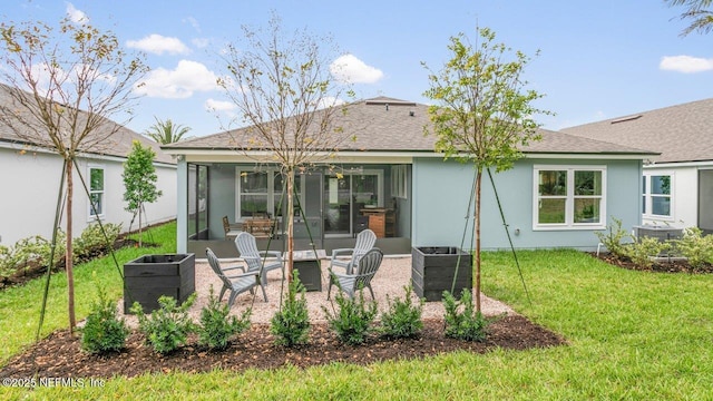 rear view of property featuring a lawn and a sunroom