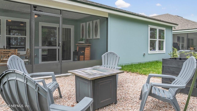 view of patio / terrace featuring a fire pit and a sunroom