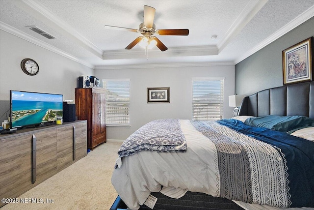 carpeted bedroom featuring a textured ceiling, ceiling fan, and a tray ceiling