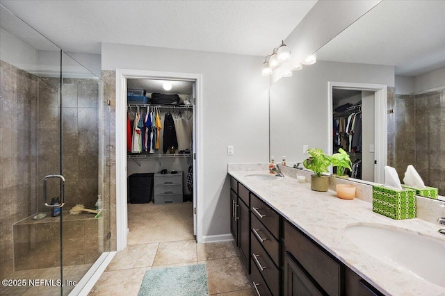 bathroom featuring vanity, walk in shower, tile patterned flooring, and a textured ceiling