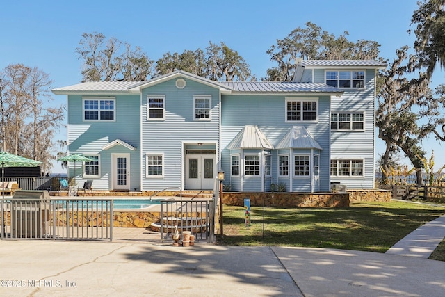 rear view of property with french doors, a yard, a fenced in pool, and a patio area