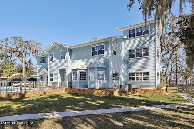 back of property with a pool and a yard