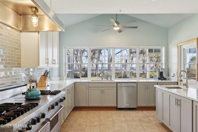 kitchen with stainless steel appliances, sink, ceiling fan, and decorative backsplash