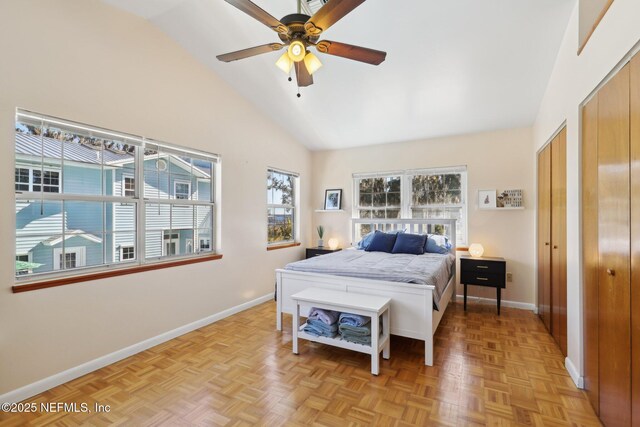 bedroom featuring multiple closets, light parquet floors, high vaulted ceiling, and ceiling fan