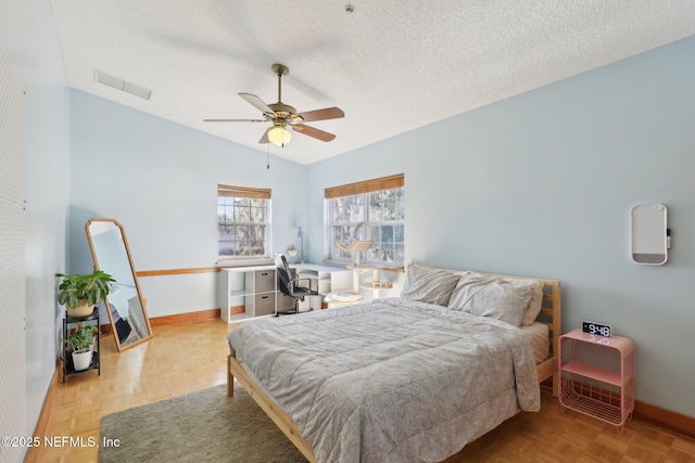 bedroom with lofted ceiling, ceiling fan, a textured ceiling, and light parquet floors