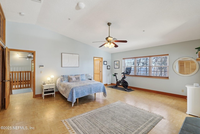 bedroom featuring a textured ceiling, vaulted ceiling, light parquet flooring, and ceiling fan