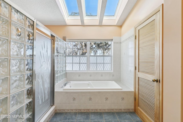 bathroom featuring a skylight, shower with separate bathtub, and a textured ceiling