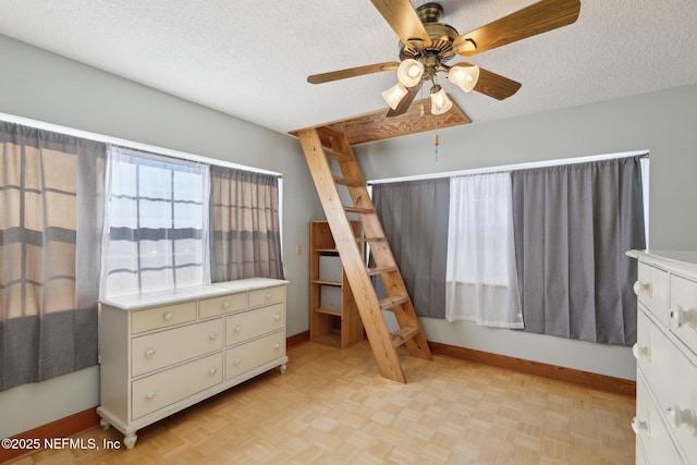 bedroom featuring ceiling fan, a textured ceiling, and light parquet floors