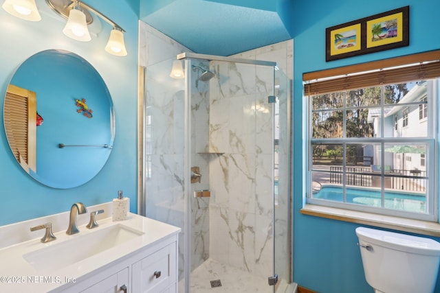 bathroom featuring vanity, an enclosed shower, and toilet