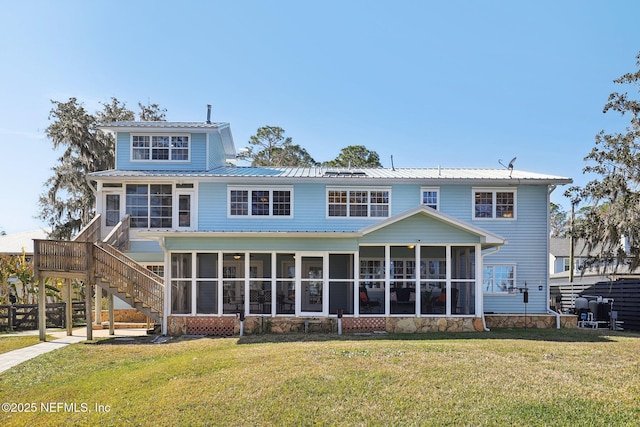 back of house featuring a sunroom and a lawn