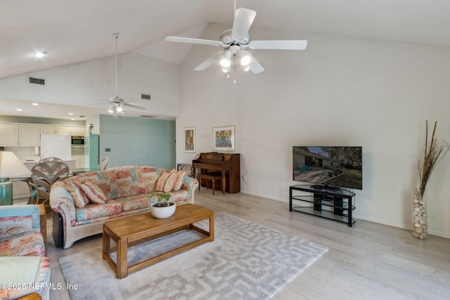 living room with light hardwood / wood-style floors, high vaulted ceiling, and ceiling fan