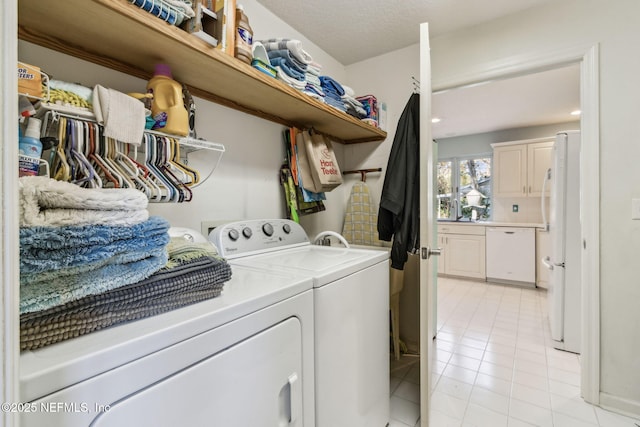 laundry area with separate washer and dryer and light tile patterned floors