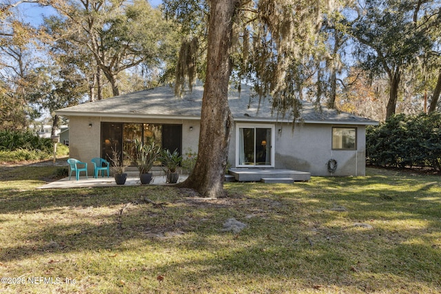 back of property with a yard and a patio area