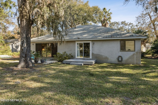 rear view of house featuring a lawn and a wooden deck