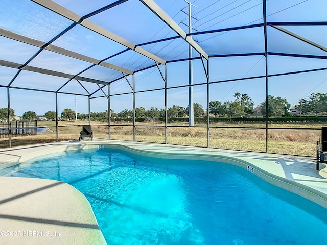 view of swimming pool featuring glass enclosure and a patio area