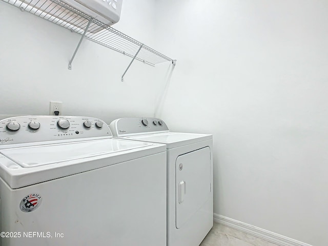 clothes washing area featuring washing machine and dryer and light tile patterned floors